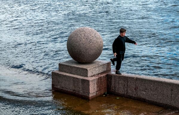 Мальчик на набережной реки Невы, в которой поднялся уровень воды из-за непогоды - Sputnik Латвия