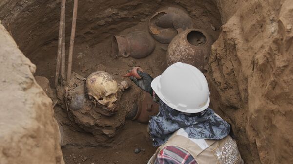 Археолог работает на месте, где городские рабочие обнаружили древние останки, Перу - Sputnik Латвия