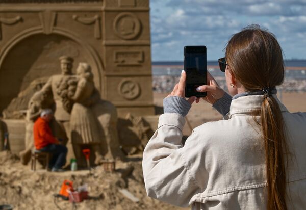 Девушка фотографирует песчаную скульптуру - Sputnik Латвия