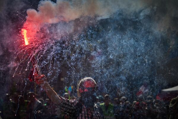 Протестующий держит факел во время многотысячного марша по центру Парижа во время демонстраций. - Sputnik Латвия