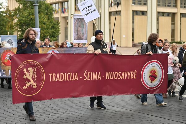 На фото: участники марша несут плакат с надписью: &quot;Традиция — семья — собственность&quot;. - Sputnik Латвия