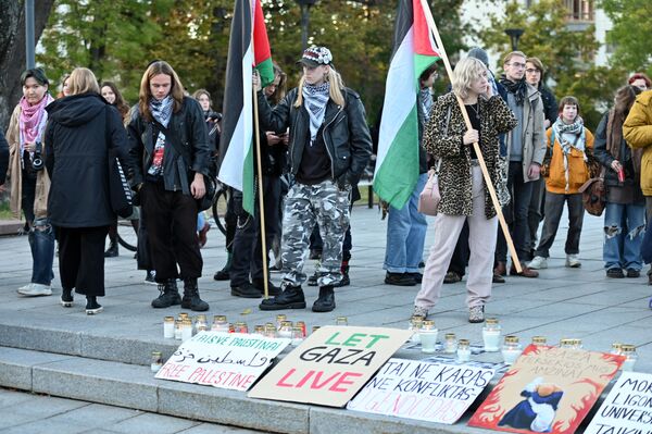 Участники акции солидарности с народом Палестины принесли флаги и плакаты, зажгли траурные свечи по погибшим. - Sputnik Латвия