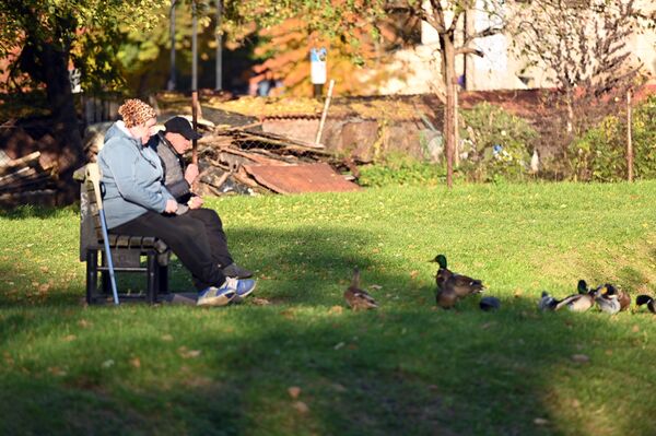 На фото: пожилые люди подкармливают уточек в парке. - Sputnik Латвия