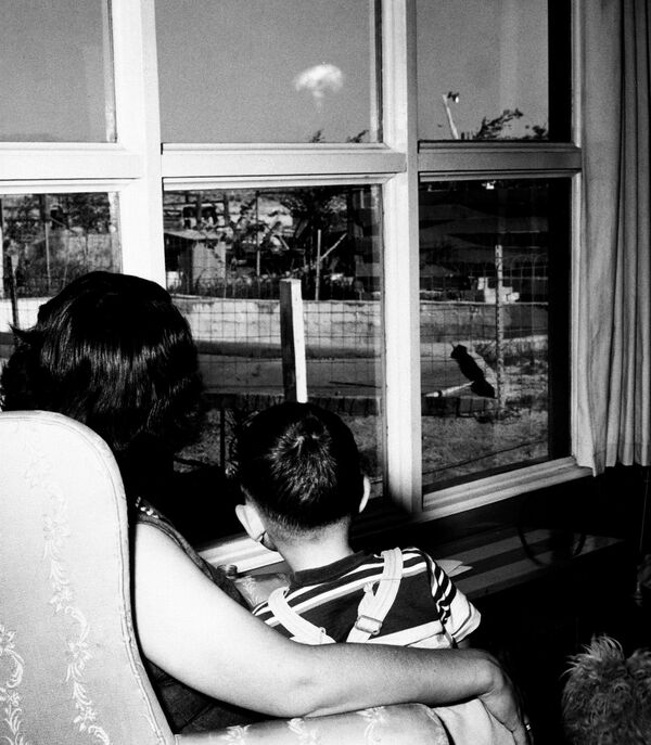 Женщина и ее маленький сын наблюдают за грибовидным облаком от ядерного взрыва, Невада, 1953 год  - Sputnik Латвия