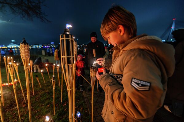 Мальчик зажигает факел у памятника Свободы  - Sputnik Латвия
