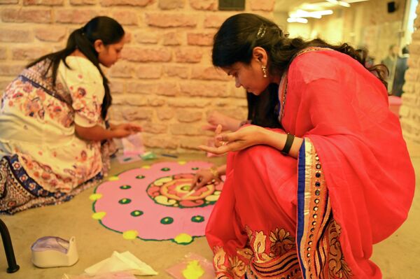 Также все желающие могли на художественных мастер-классах научиться создавать традиционные рисунки ранголи из цветного порошка и цветов. - Sputnik Латвия