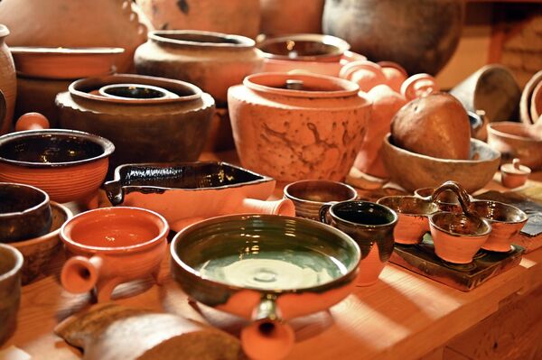 Посетители мастерской могут слушать рассказы мастеров, попивая кофе из реконструированных чашек, а могут даже попробовать сами вдохнуть жизнь в глину. - Sputnik Латвия