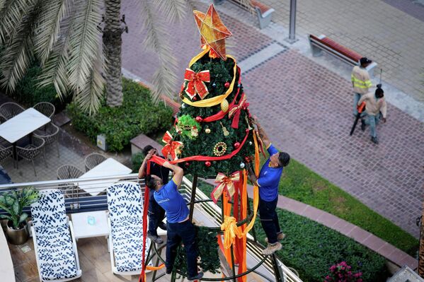 Рабочие украшают рождественскую елку в Дубае, ОАЭ. - Sputnik Латвия