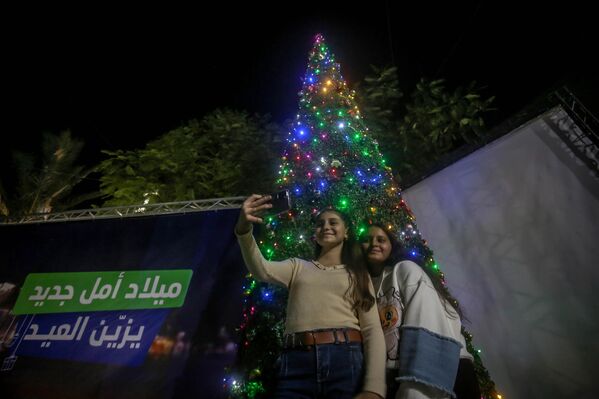 Люди позируют перед рождественской елкой в Газе  - Sputnik Латвия