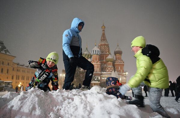 Дети играют в сугробе во время снежной погоды на Красной площади в Москве, Россия - Sputnik Латвия
