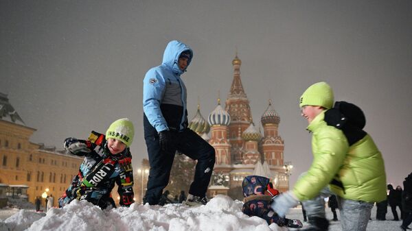 Дети играют в сугробе во время снежной погоды на Красной площади в Москве, Россия - Sputnik Латвия