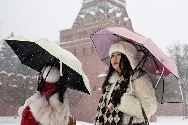 Иностранные туристы во время снегопада на Красной площади в Москве, Россия - Sputnik Латвия