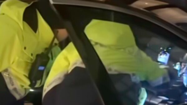 Сотрудники латвийской полиции фотографируют прослушивающее устройство, найденное в машине Алексея Росликова  - Sputnik Латвия