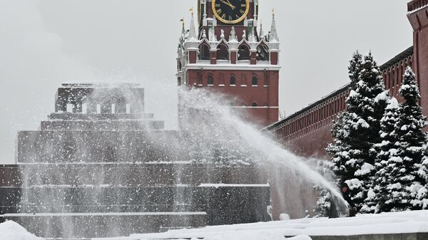 Сотрудник коммунальной службы убирает снег у Кремлевской стены на Красной площади в Москве - Sputnik Латвия
