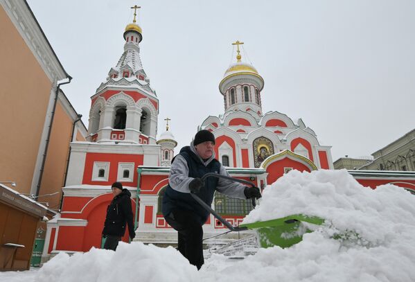 Мужчина убирает снег у собора Казанской иконы Божией Матери на Никольской улице - Sputnik Латвия