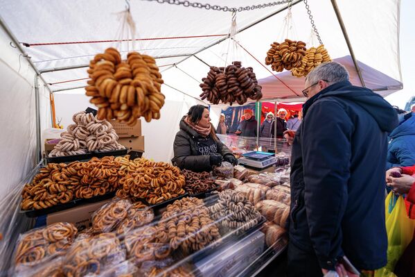 На фото: посетитель ярмарки осматривает ассортимент хлебобулочных изделий  - Sputnik Латвия