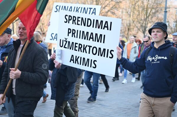 На фото: участники акции протеста несут плакат с надписью: &quot;Решения принимаются с закрытыми глазами&quot;. - Sputnik Латвия