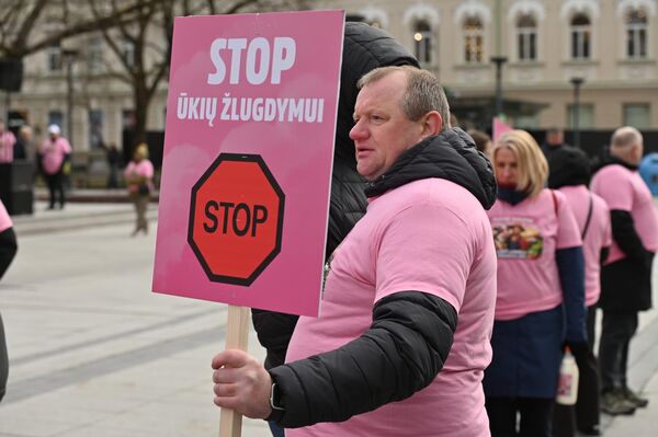 На фото: участник акции протеста держит плакат с надписью: "Стоп уничтожению сельского хозяйства". - Sputnik Латвия