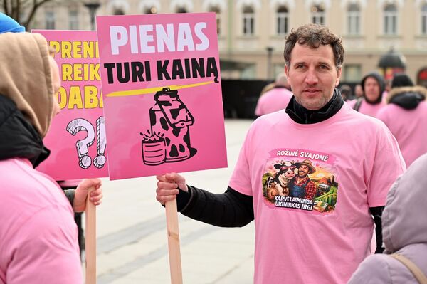 На фото: участник акции протеста держит плакат с надписью: "У молока есть цена". - Sputnik Латвия