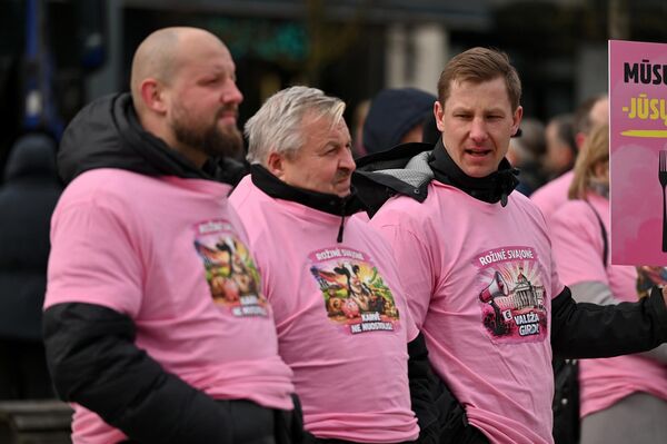 Участники акции были одеты в розовые майки с надписью: "Розовая мечта прожить с молочного хозяйства". - Sputnik Латвия