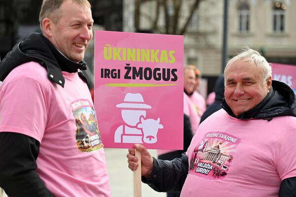 На фото: участник акции протеста держит плакат с надписью: "Фермер тоже человек". - Sputnik Латвия