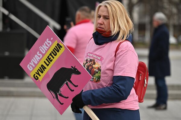 На фото: участница акции протеста держит плакат с надписью: "Живое сельское хозяйство — жива Литва". - Sputnik Латвия