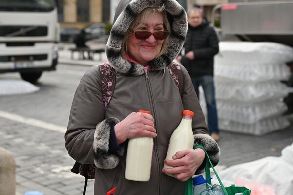 На фото: жительница Вильнюса с бесплатным молоком.  - Sputnik Латвия