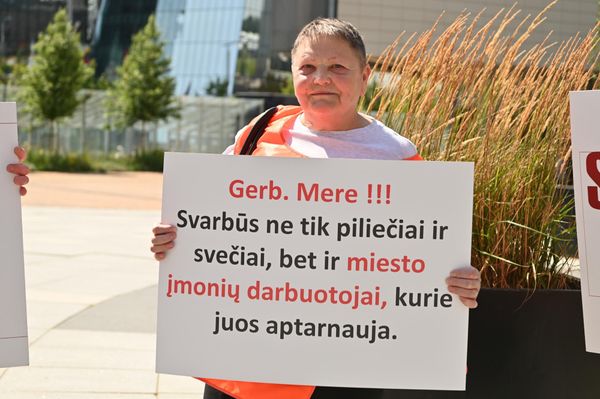 На фото: участница пикета держит плакат с надписью: "Уважаемый мэр! Важны не только граждане и гости, но и работники городских предприятий, которые их обслуживают". - Sputnik Латвия