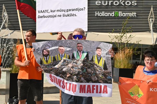 На фото: участник пикета держит плакат, на котором изображены представители власти, и имеется подпись: "Мусорная мафия". - Sputnik Латвия