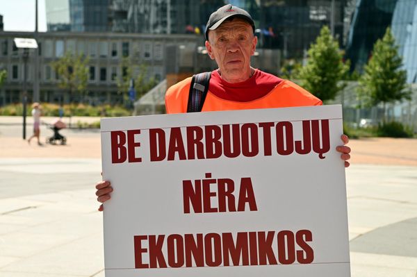 На фото: участник пикета держит плакат с надписью: "Без работников нет экономики". - Sputnik Латвия