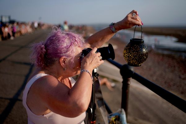 Женщина фотографирует частичное солнечное затмение на пляже Кросби в Ливерпуле   - Sputnik Латвия