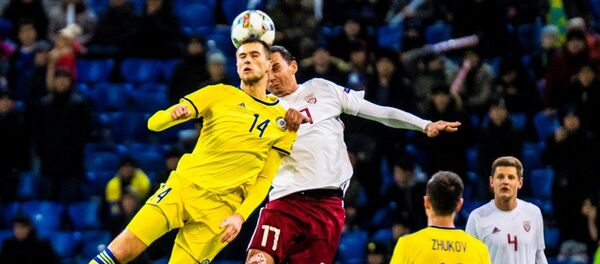 Роман Муртазаев (слева) бьется за мяч с игроком сборной Латвии в матче Лиги наций, Астана, 16 ноября 2018 года Роман Муртазаев (слева) бьется за мяч с игроком сборной Латвии в матче Лиги наций, Астана, 16 ноября 2018 года - Sputnik Латвия