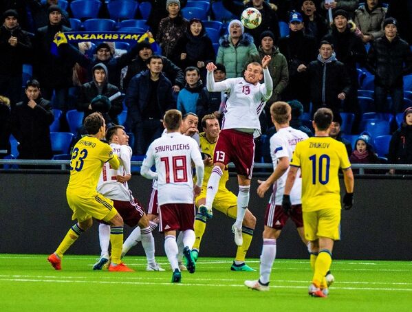 Латвиец Вячеслав Исаев (в центре) отбивает мяч в матче Лиги наций против Казахстана, Астана, 15 ноября 2018 года - Sputnik Латвия