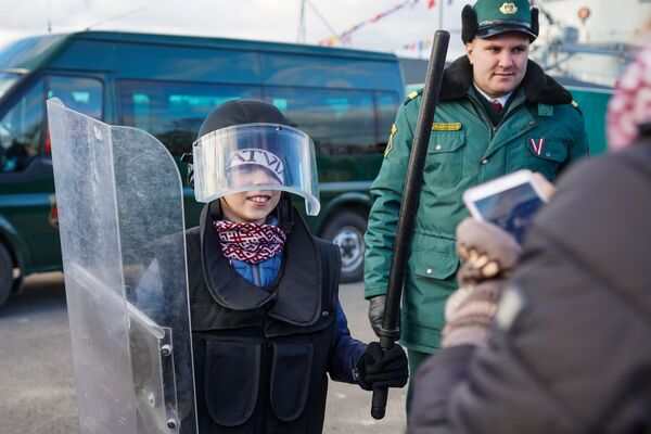 Мальчик фотографируется в защитном комплекте для разгона беспорядков - Sputnik Латвия
