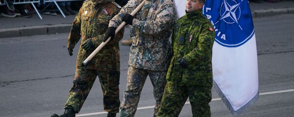 Немецкий, латвийский и канадский военные с флагом Расширенной передовой группы НАТО в Латвии Немецкий, латвийский и канадский военные с флагом Расширенной передовой группы НАТО в Латвии - Sputnik Latvija