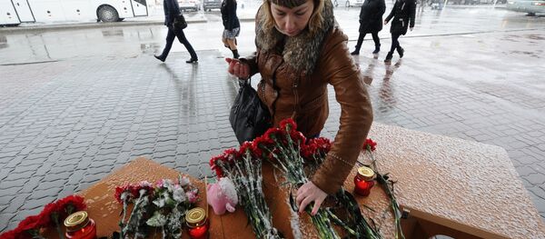 Женщина возлагает цветы у аэропорта Ростова-на-Дону Женщина возлагает цветы у аэропорта Ростова-на-Дону - Sputnik Латвия