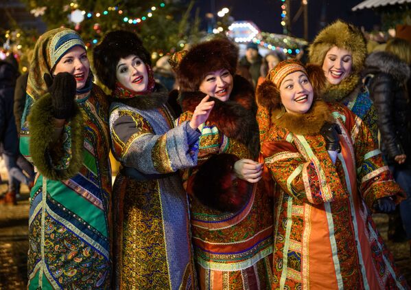 Женщины в традиционных костюмах развлекают посетителей на Рождественском ярмарке на Красной площади в Москве  - Sputnik Латвия