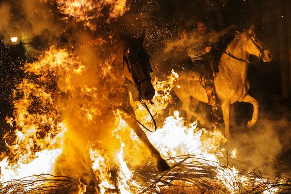 Всадники проезжают через огонь во время ежегодного фестиваля Las Luminarias в испанской деревне Сан-Бартоломе-де-Пинарес - Sputnik Латвия