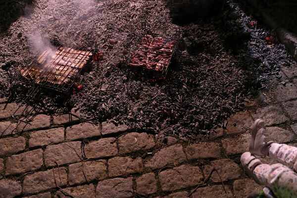 Люди во время приготовления мяса накануне фестиваля Las Luminarias в Испании  - Sputnik Латвия