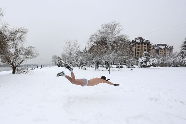 Участник ныряет в снег во время зимнего забега в трусах в Белграде - Sputnik Латвия