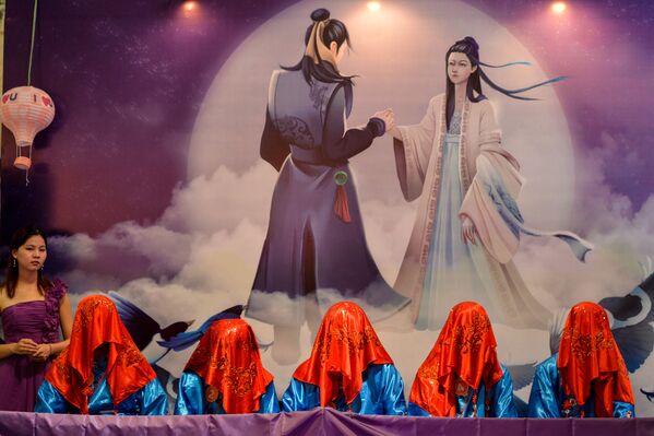 Китайские мужчины, покрытые платками, во время конкурса, в котором их невесты должны их отгадать во время Цисицзе - китайского Дня святого Валентина в Шанхае - Sputnik Латвия