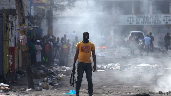 Мужчина с оружием во время антиправительственных протестов в Порт-о-Пренсе, Гаити, 17 февраля 2019 - Sputnik Латвия