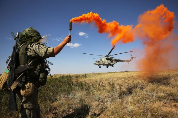 Военнослужащий подает сигнал дымовой ракетой пилоту вертолета Ми-8 во время ротно-тактических учений Южного военного округа, 2018 год - Sputnik Латвия