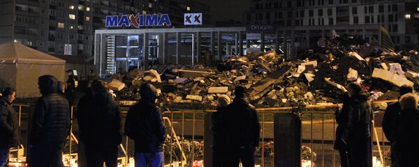 Горожане возлагают цветы и зажигают свечи на месте трагедии в Риге - Sputnik Латвия