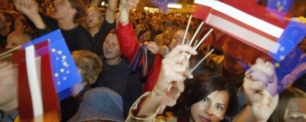 Жители Латвии с флажками Латвии и ЕС. Жители Латвии с флажками Латвии и ЕС. - Sputnik Latvija