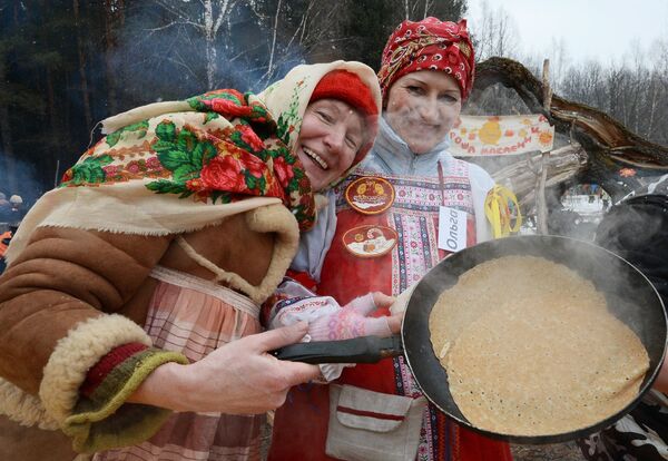 Отдыхающие готовят блины на празднике Бакшевская масленица в Московской области - Sputnik Латвия