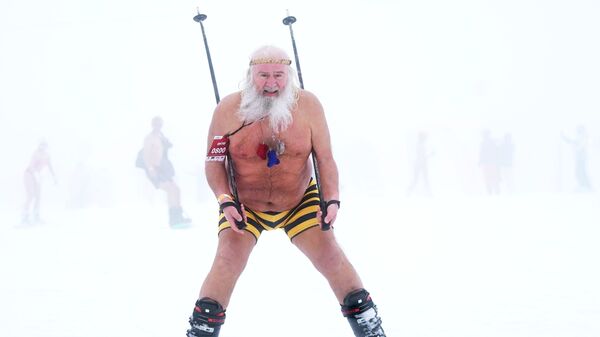 Участник высокогорного карнавала BoogelWoogel-2019 во время массового спуска с горы в купальниках на горнолыжном курорте Роза Хутор в Сочи - Sputnik Латвия