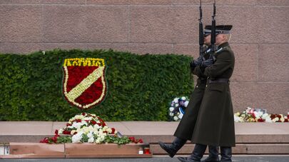 Собранное из цветов изображение шеврона латышского легиона СС у Памятника Свободы в Риге