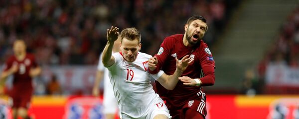 Поляк Томаш Кендзера (слева) и латвиец Артур Карашаускас в отборочном матче чемпионата Европы 2020 года - Sputnik Латвия