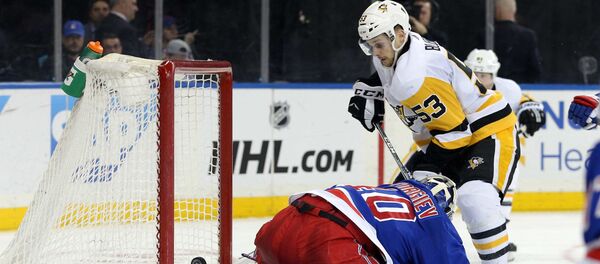 Латвийский хоккеист Теодорс Блюгерс забивает гол в матче против Нью-Йорк Рейнджерс 25 марта 2019 года - Sputnik Латвия